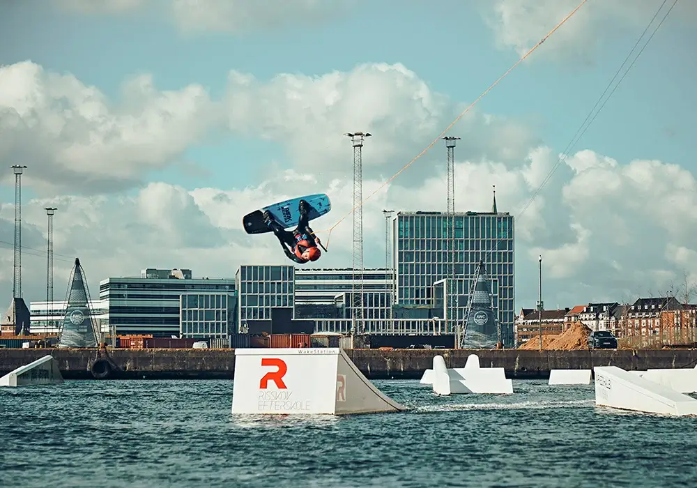 En elev laver et højt hop på wakeboard i Aarhus Watersports Complex som en del af skolens vandsport.