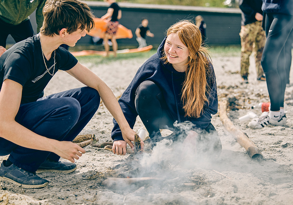 To elever hygger sig med madlavning over åben ild under en outdoor-tur med Risskov Efterskole.